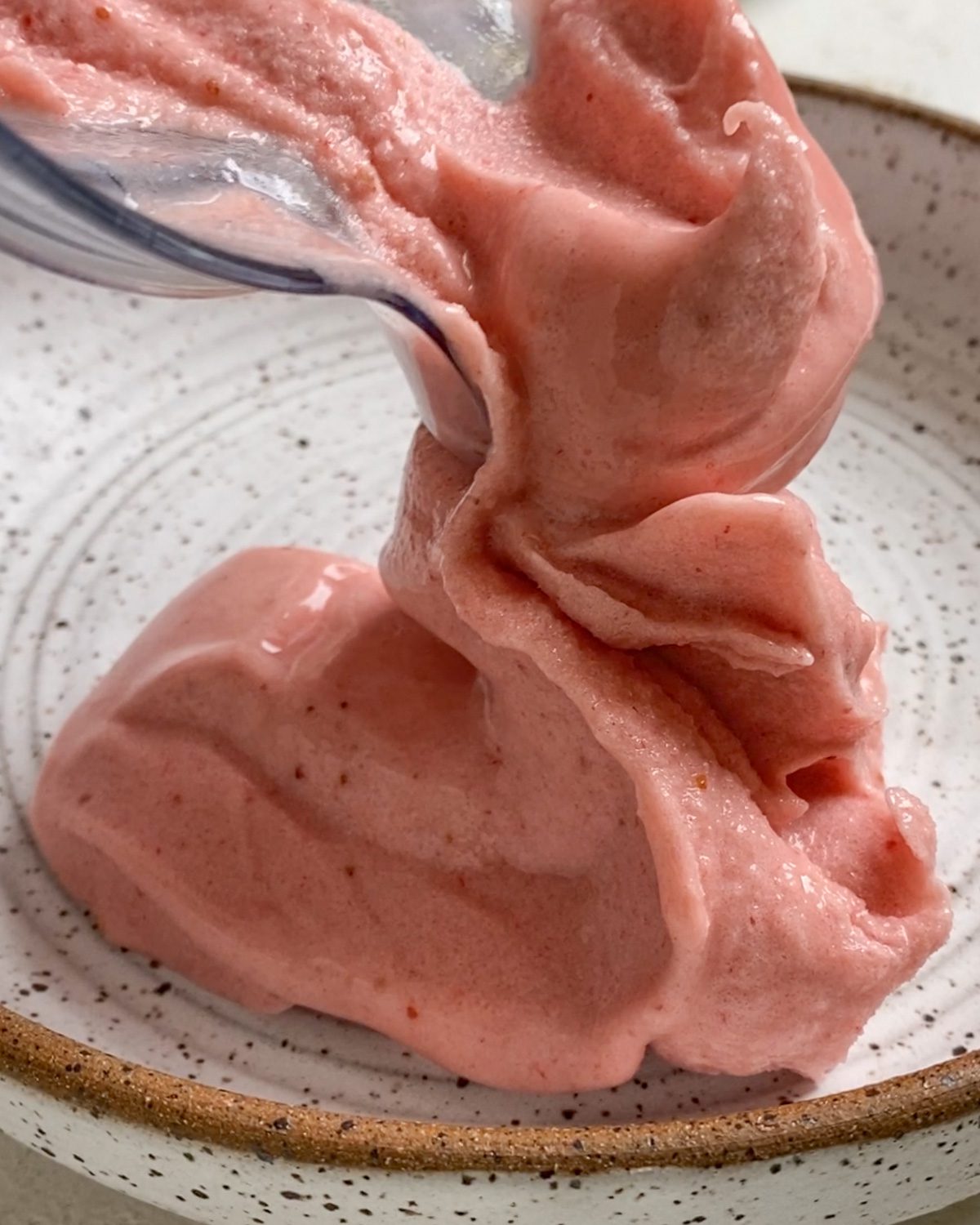 process of putting Strawberry Smoothie in a bowl