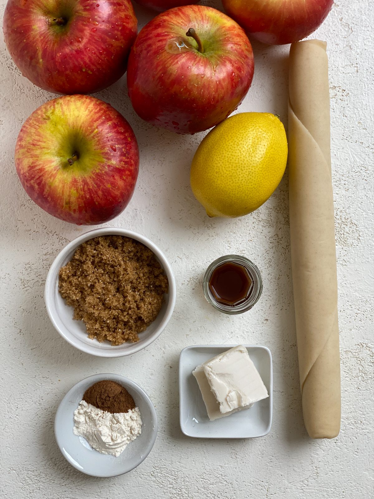 Ingredients for Vegan Apple Pie Baked Apples measured out on a white surface.
