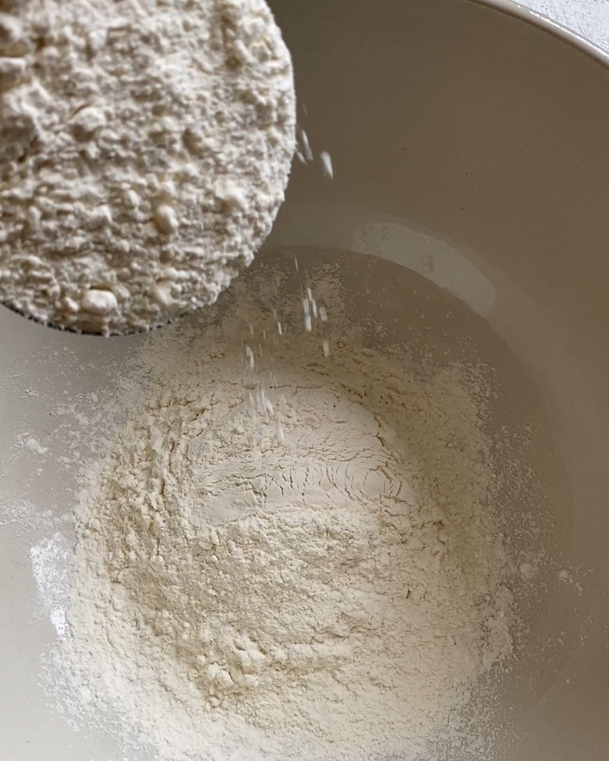 process of adding flour to mixture in bowl