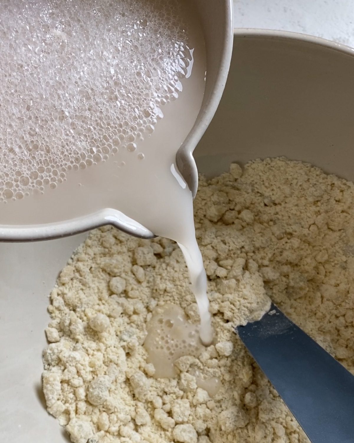 process of adding flour mixture to bowl