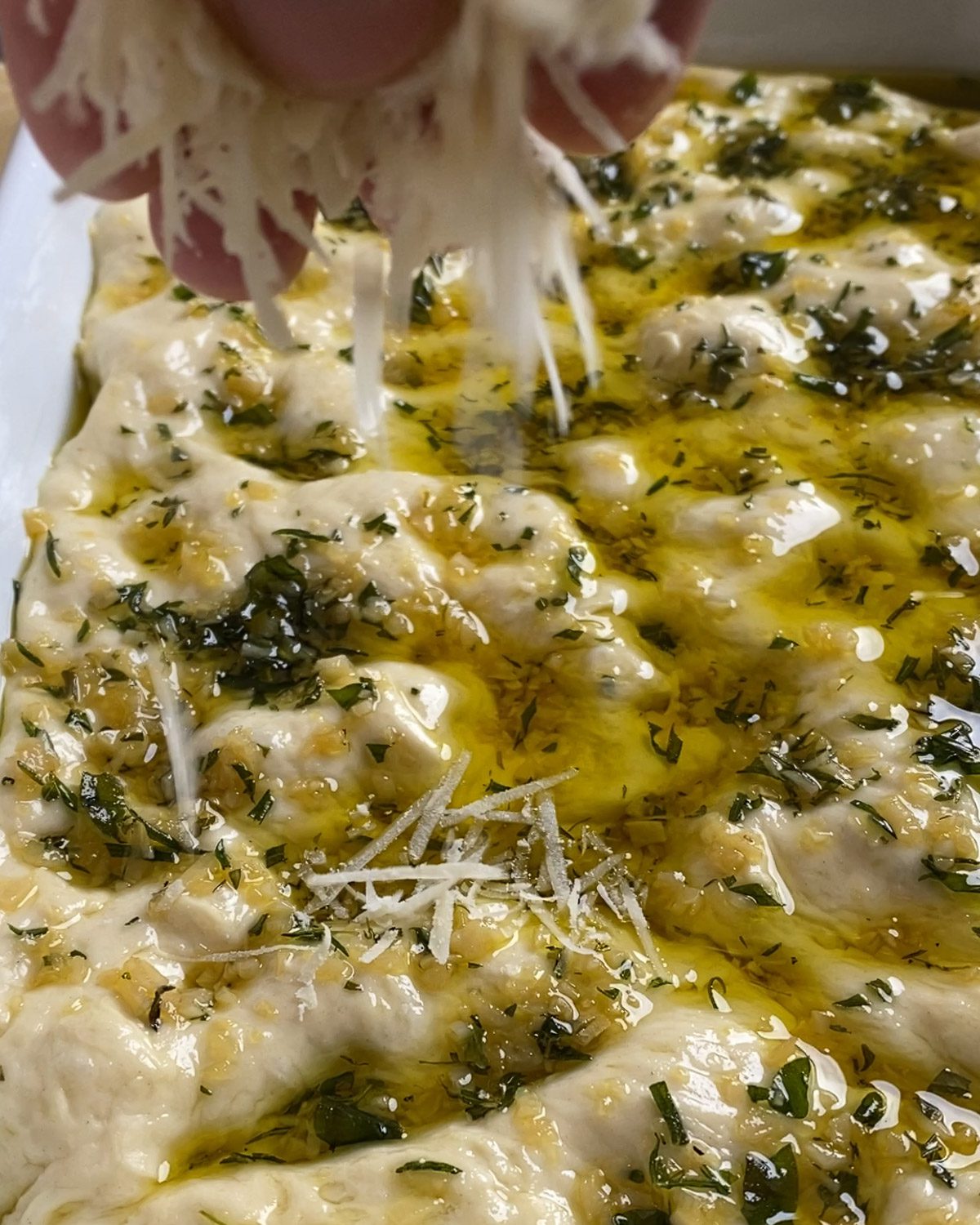 process of adding grated vegan cheese on top of unbaked dough