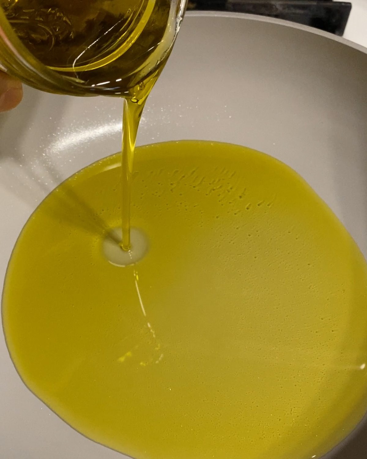 process of pouring oil into a pan
