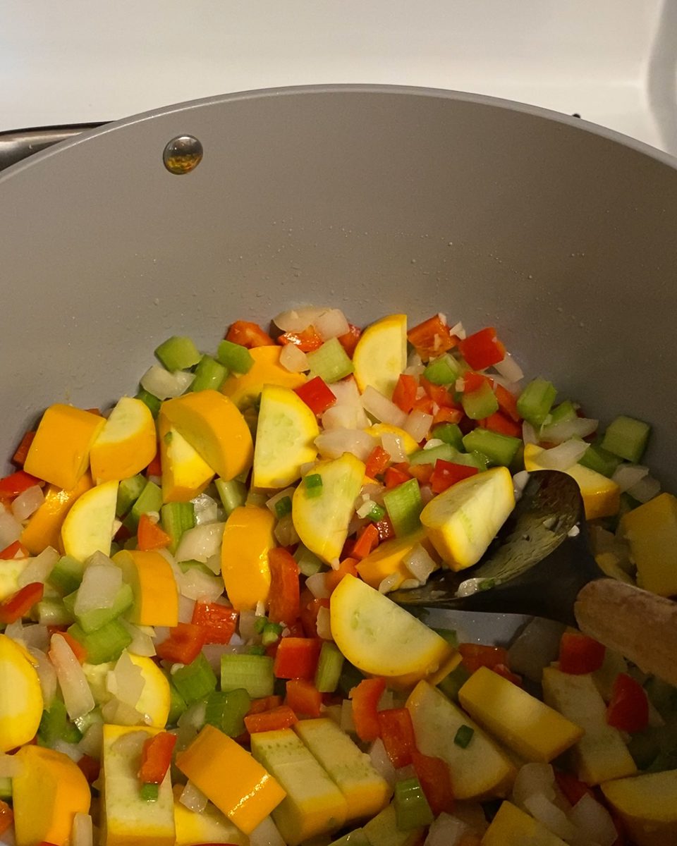 Processing of mixing veggies together in a pan.