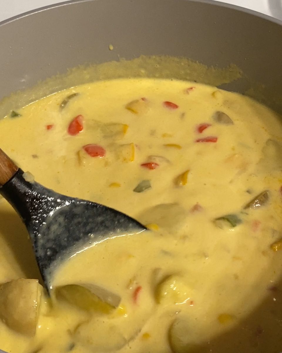 Process of mixing corn chowder in a pan.
