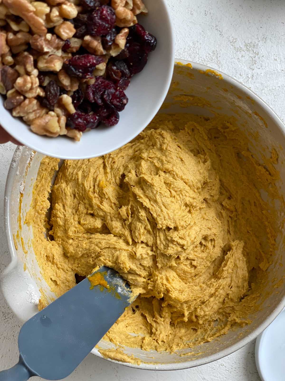 process shot of adding of nuts and fruits to dough