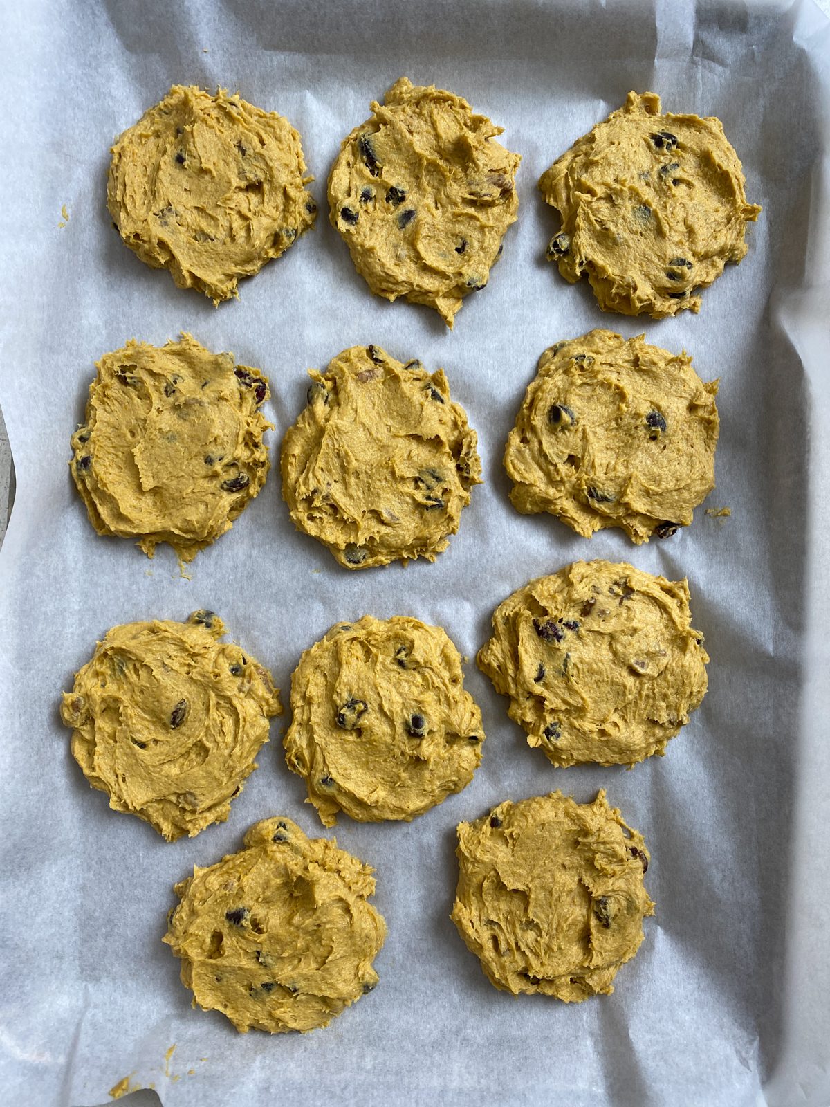 pre-baked Soft Gluten-Free Pumpkin Cookies spread out on a baking sheet