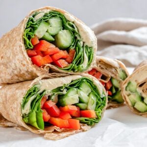 completed hummus wraps against a light surface stacked on one another