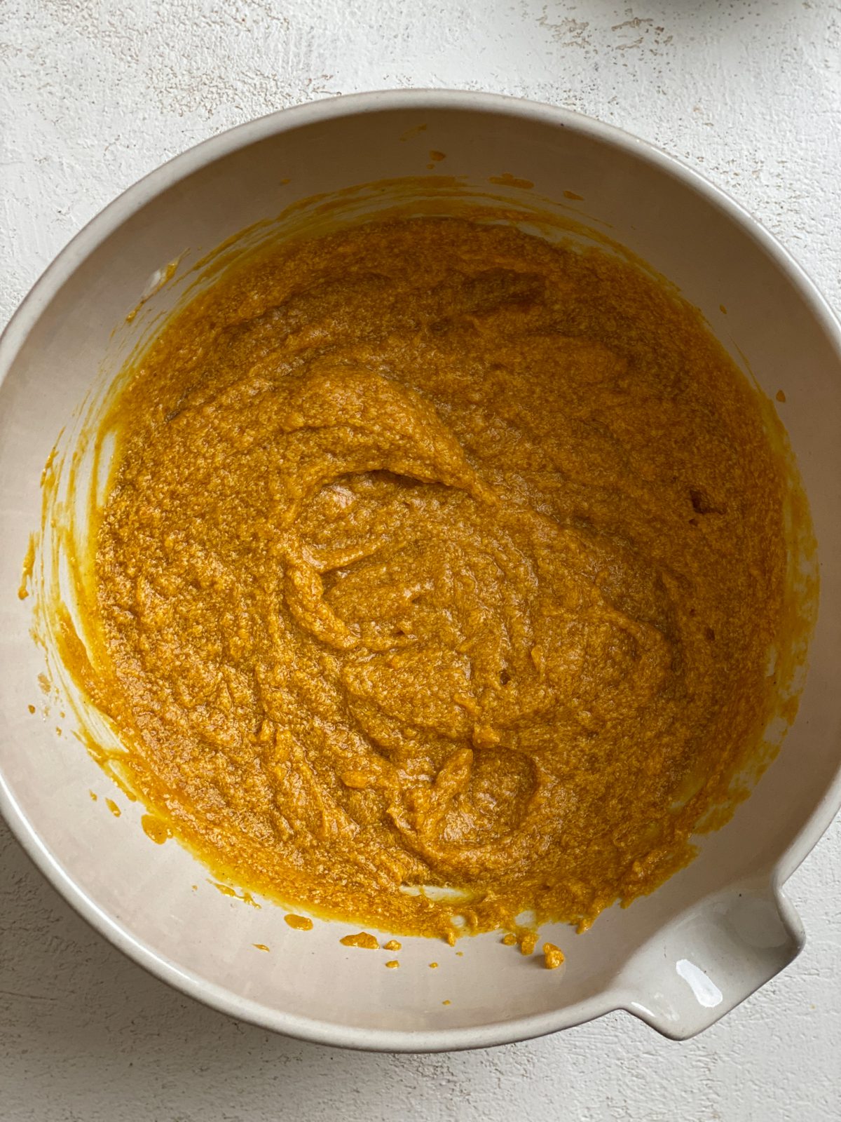 process shot of mixing Easy Vegan Pumpkin Muffins ingredients in a bowl