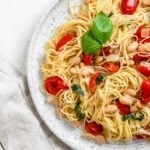 completed Vegan Tomato Basil Angel Hair Pasta in a white plate against a light background