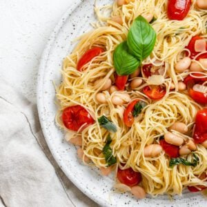 completed Vegan Tomato Basil Angel Hair Pasta in a white plate against a light background
