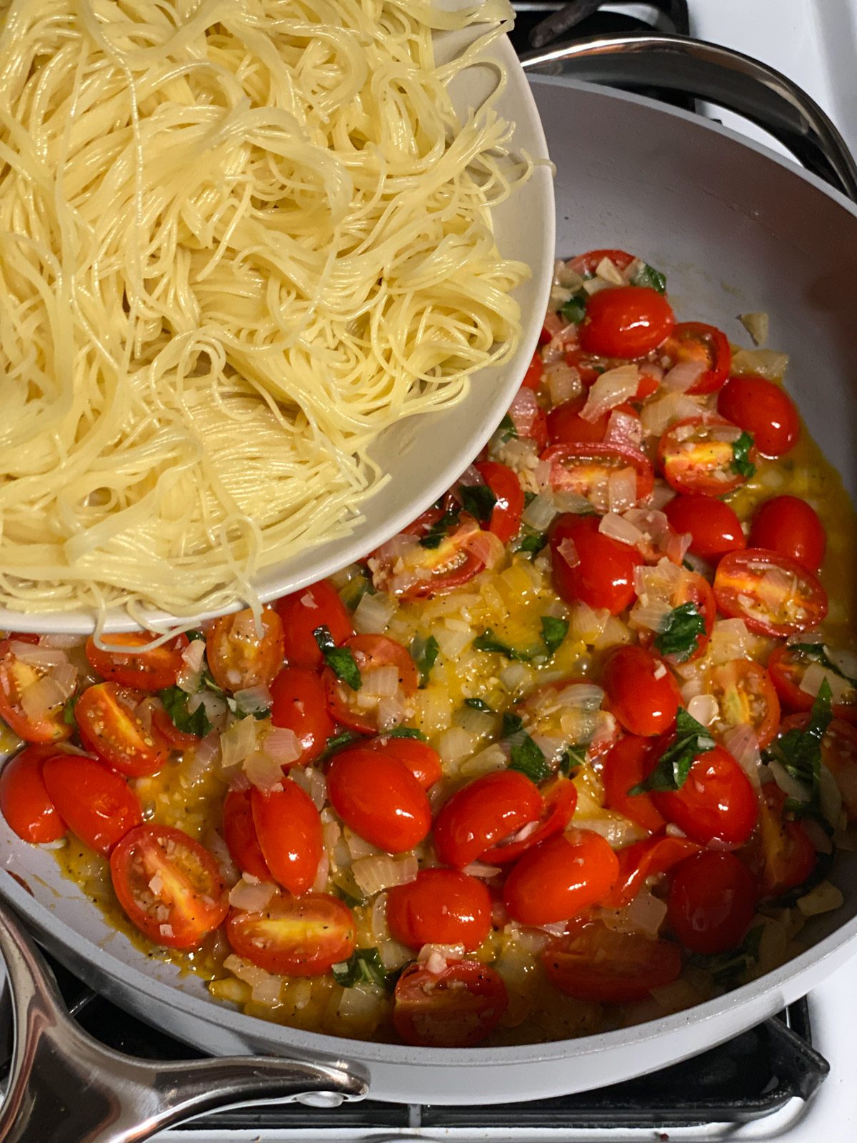 Process shot of adding noodles to pan.