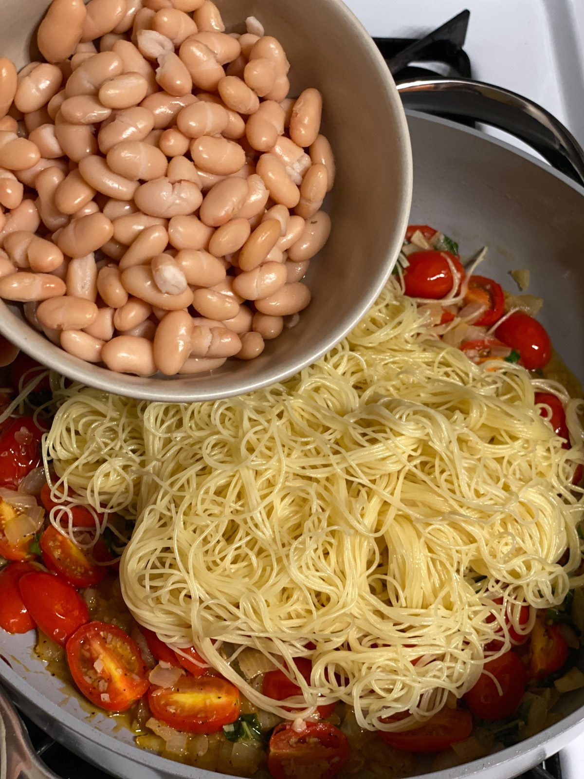 Process shot of adding beans to pan.
