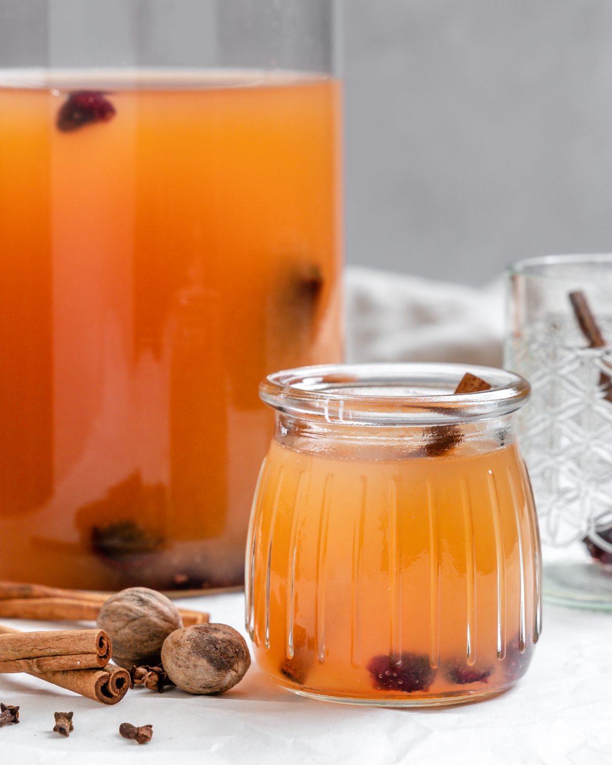 completed Vegan Instant Pot Apple Cider in two glass containers on a white surface