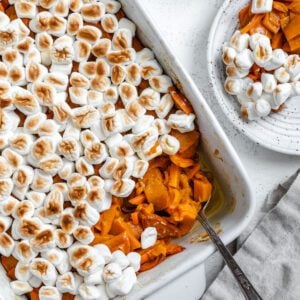 completed Vegan Candied Yams with Marshmallows in a baking dish against a white background