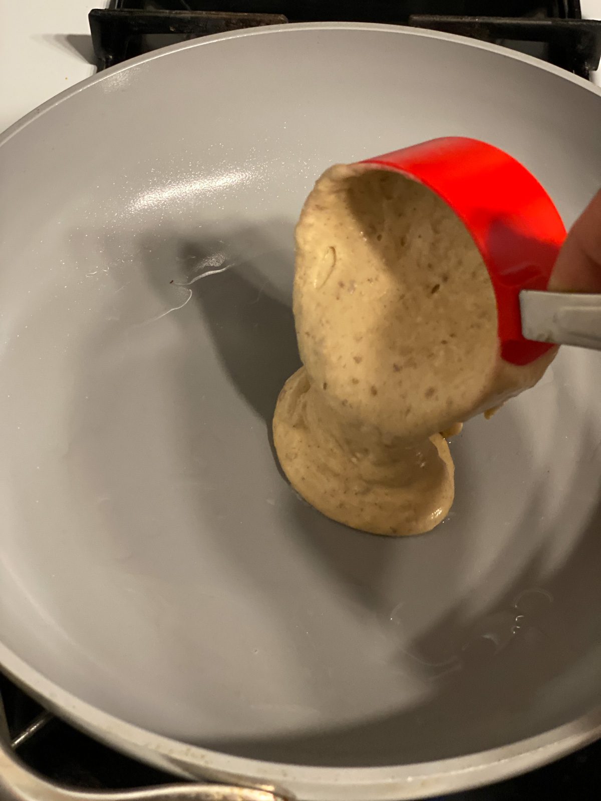 process shot of pouring Vegan Pumpkin Pancake batter onto skillet