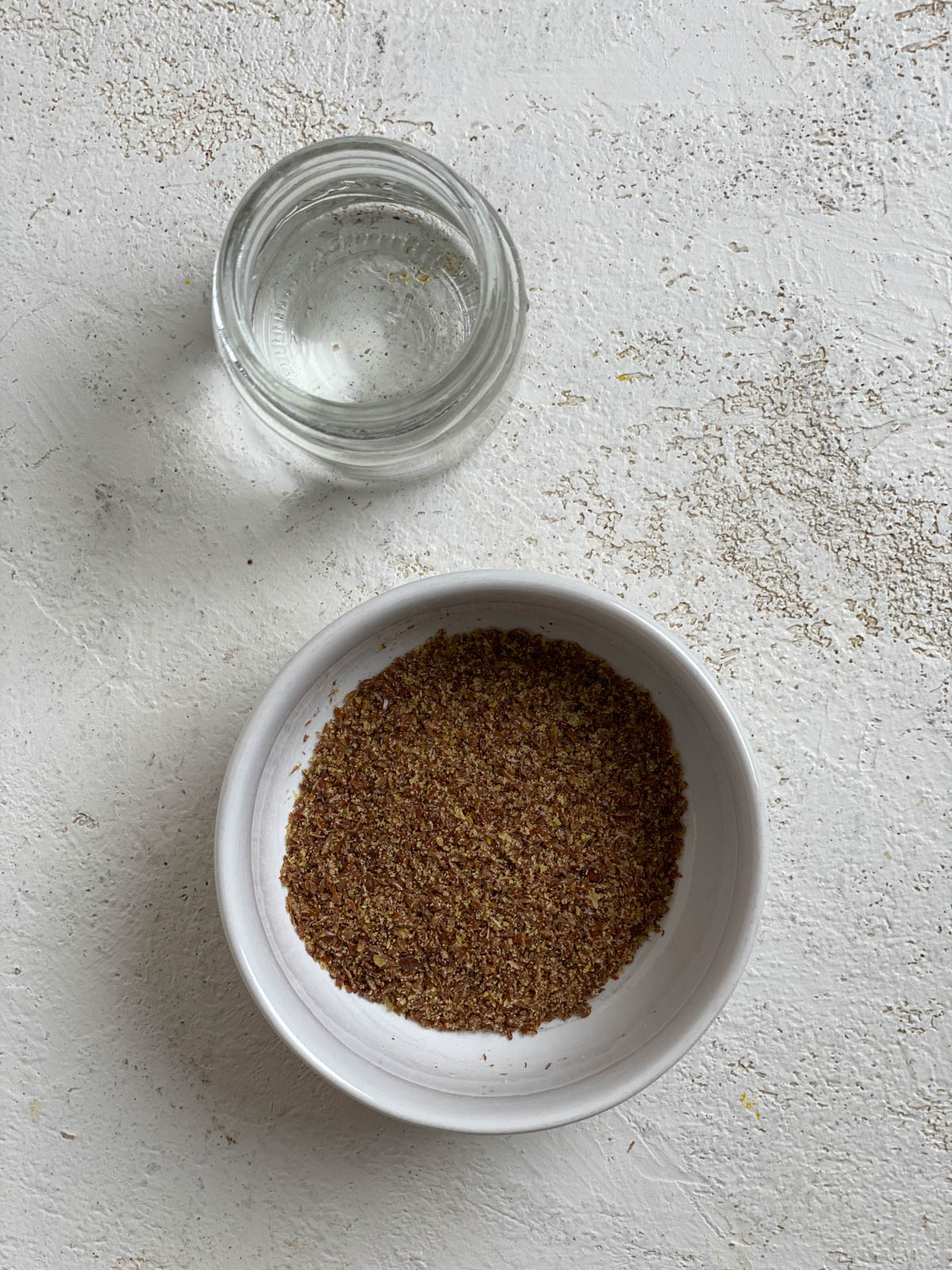 bowl of flaxseed and water against a white surface