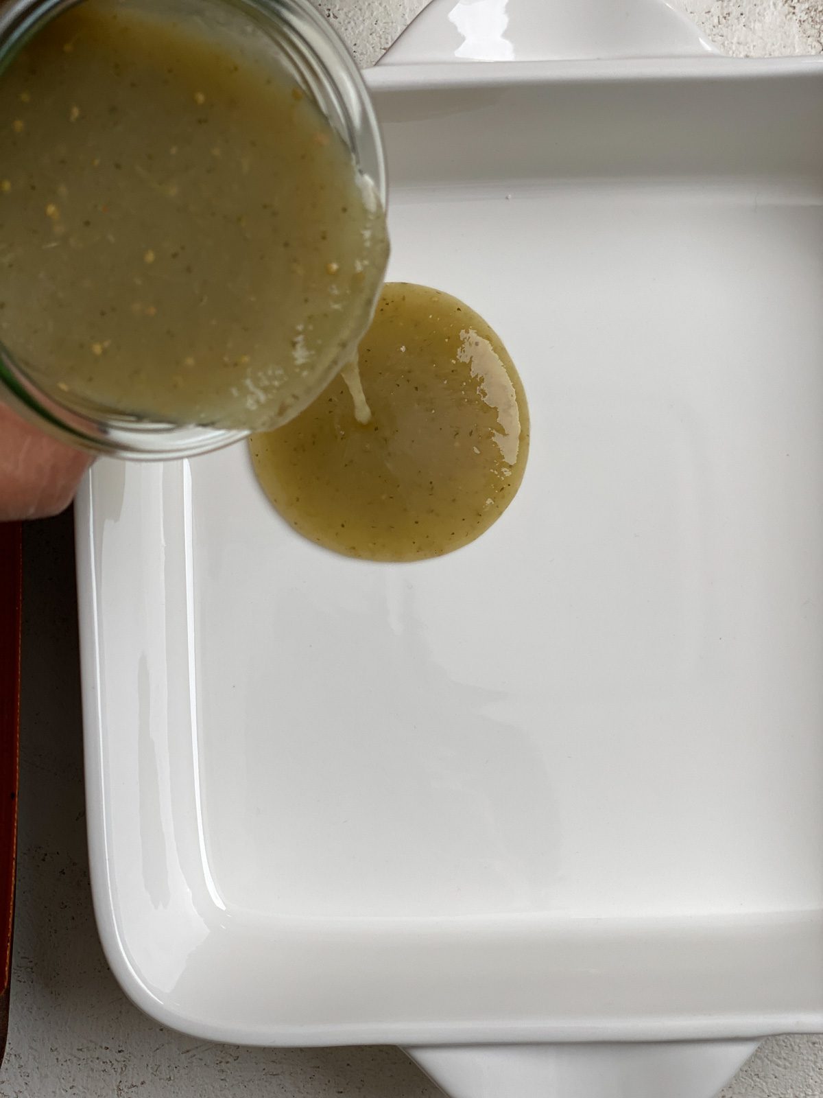 process shot of adding sauce to baking pan