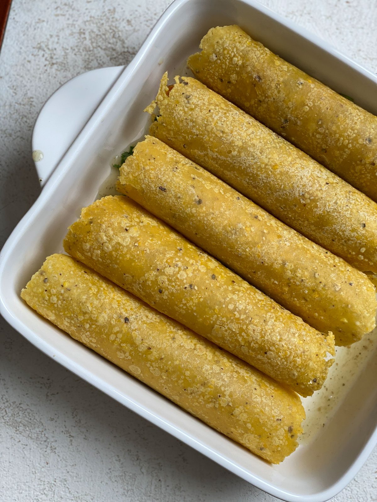five enchiladas pre-cooked in a baking dish