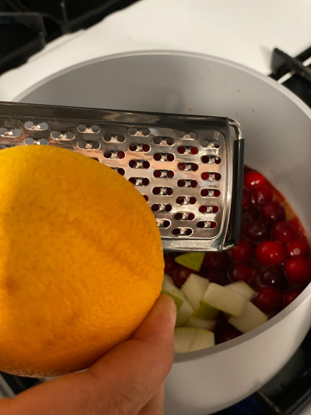 process shot of adding orange zest to pan
