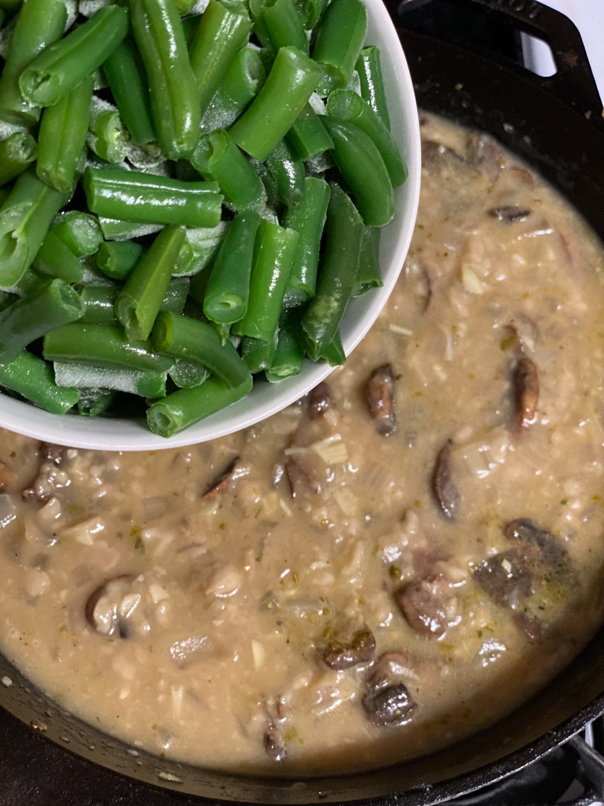 process shot of adding green beans to pan