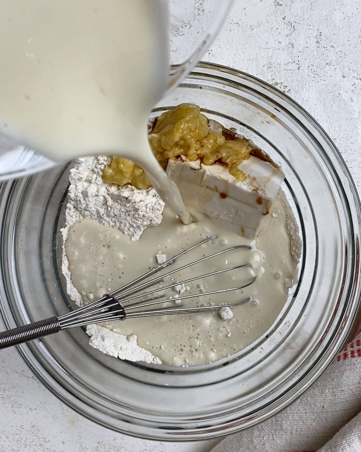 process of adding milk and vinegar ingredients to bowl