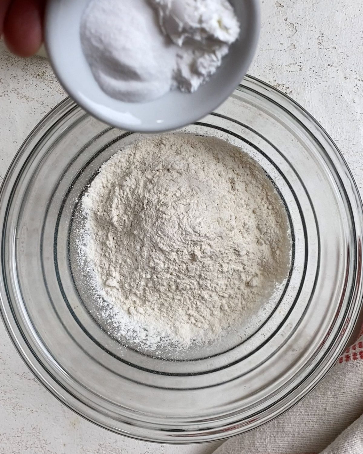 process of adding leavening agents to bowl of flour