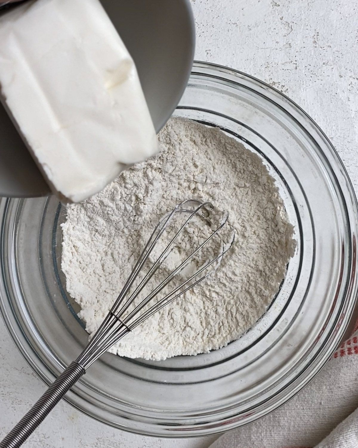 process of adding butter to bowl