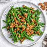 completed Brown Sugar Green Beans [No Bacon] plated on a white plate against a white surface