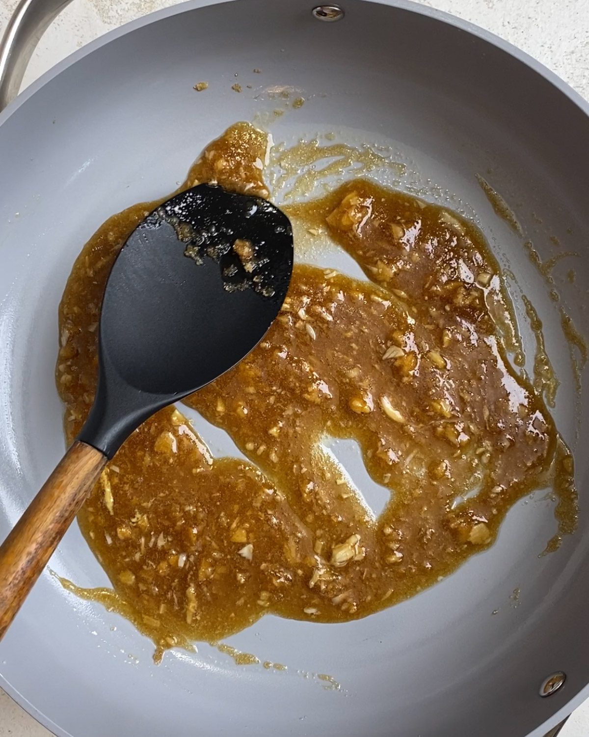 Process of mixing ingredients for Brown Sugar Green Beans [No Bacon] in a pan.