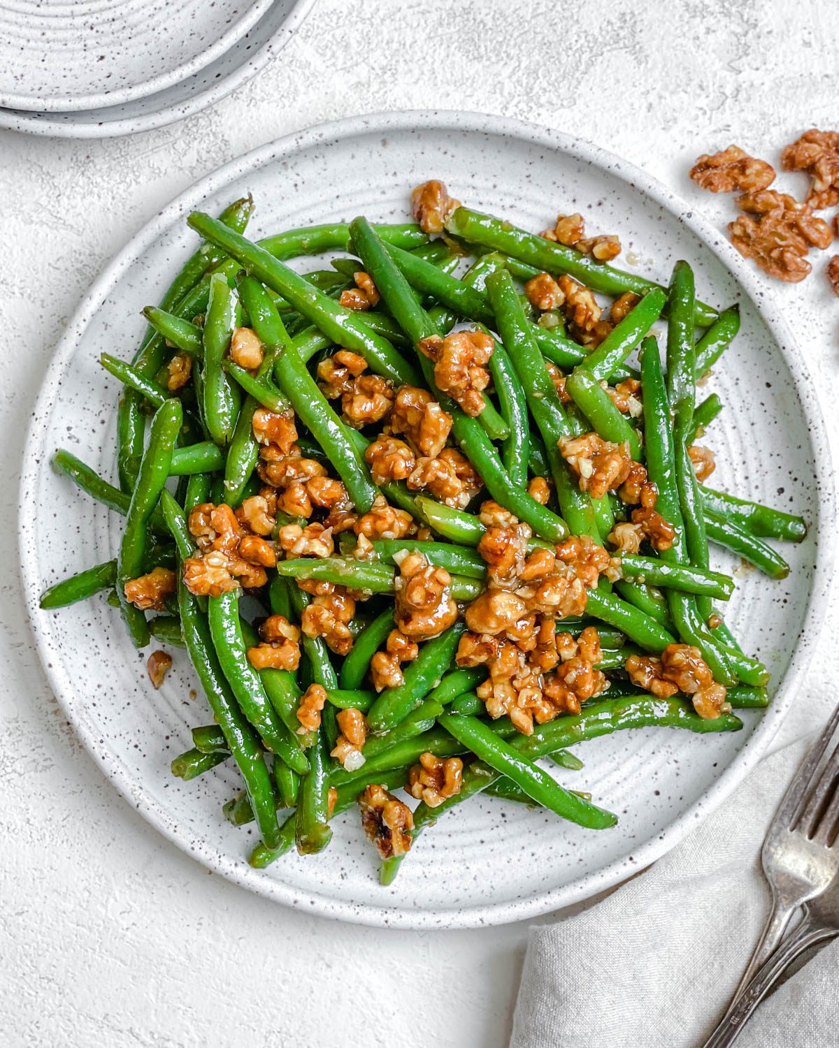 Completed Brown Sugar Green Beans [No Bacon] plated on a white plate against a white surface.