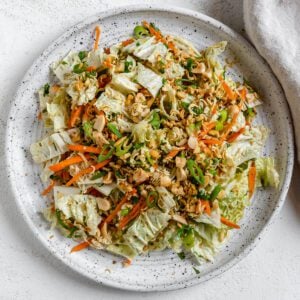 completed Ramen Noodle Cabbage Salad on a white plate against a white background