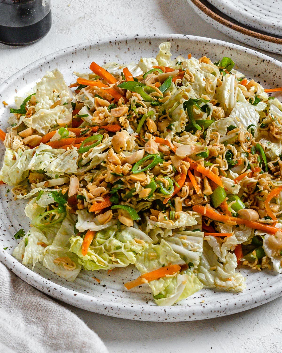 completed Ramen Noodle Cabbage Salad on a white plate against a white background