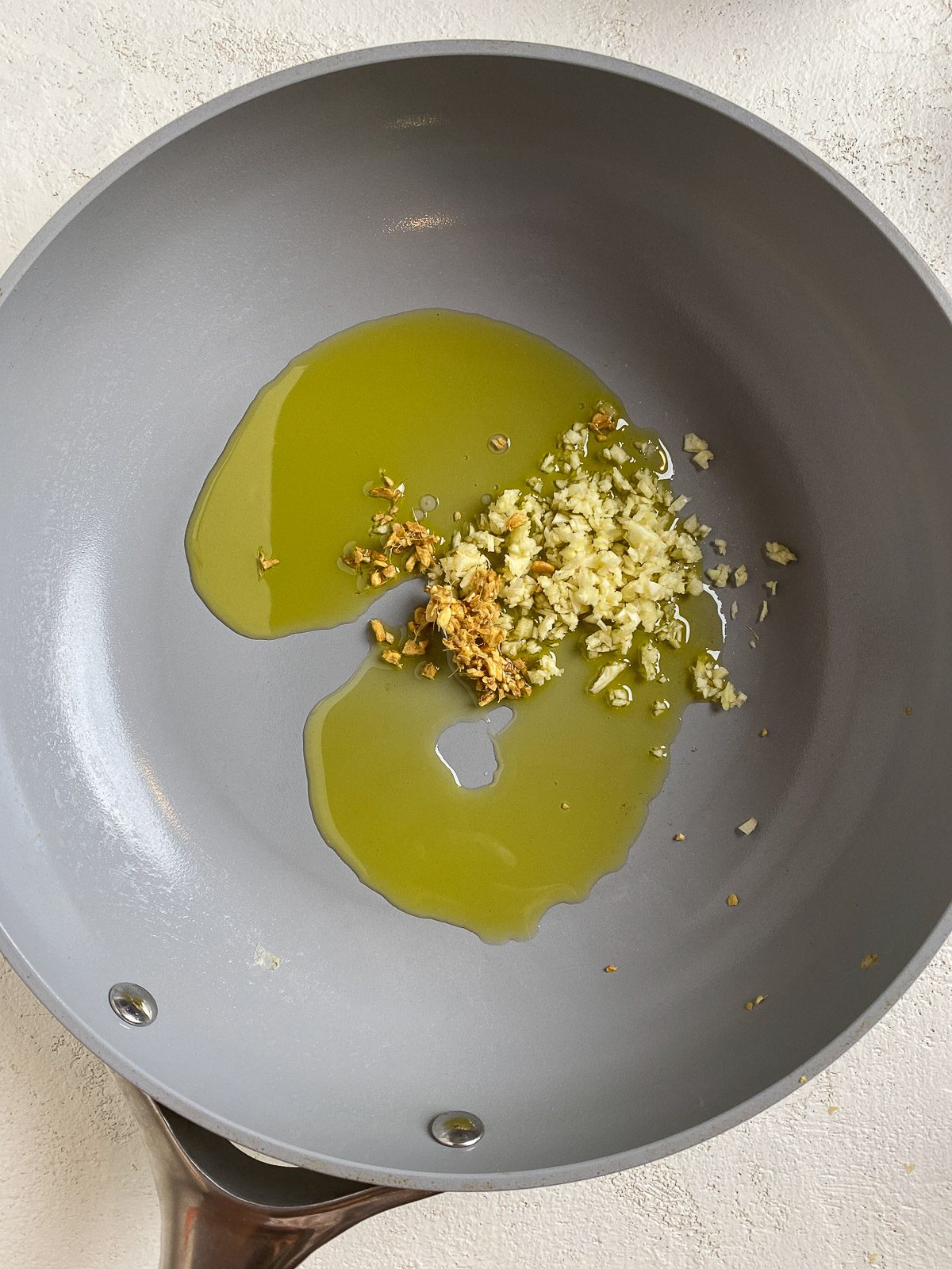 process shot of garlic cooking in oil in pan