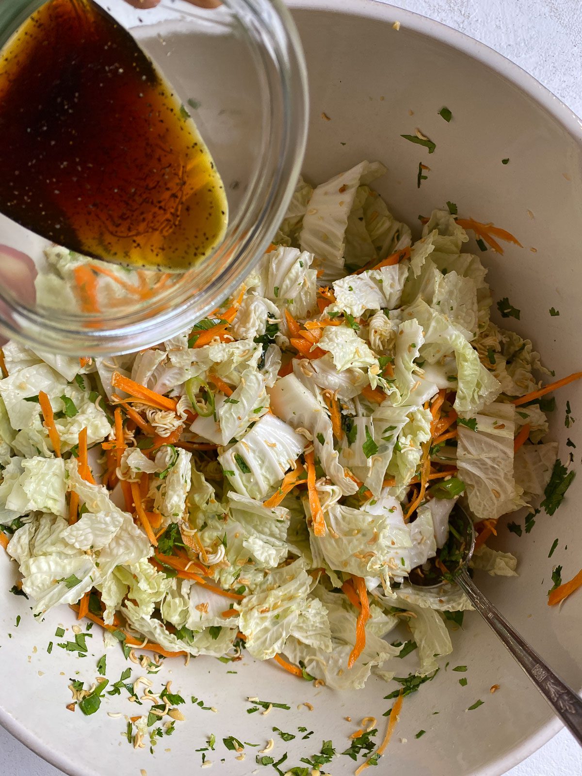 process shot of pouring dressing on top of salad
