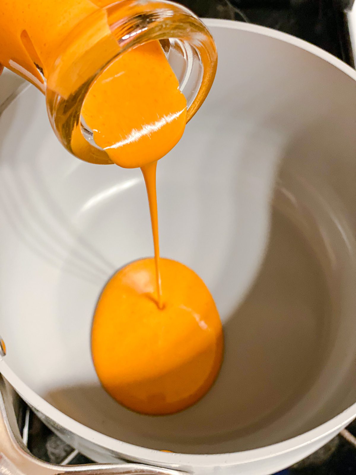 Process of adding buffalo sauce to bowl.