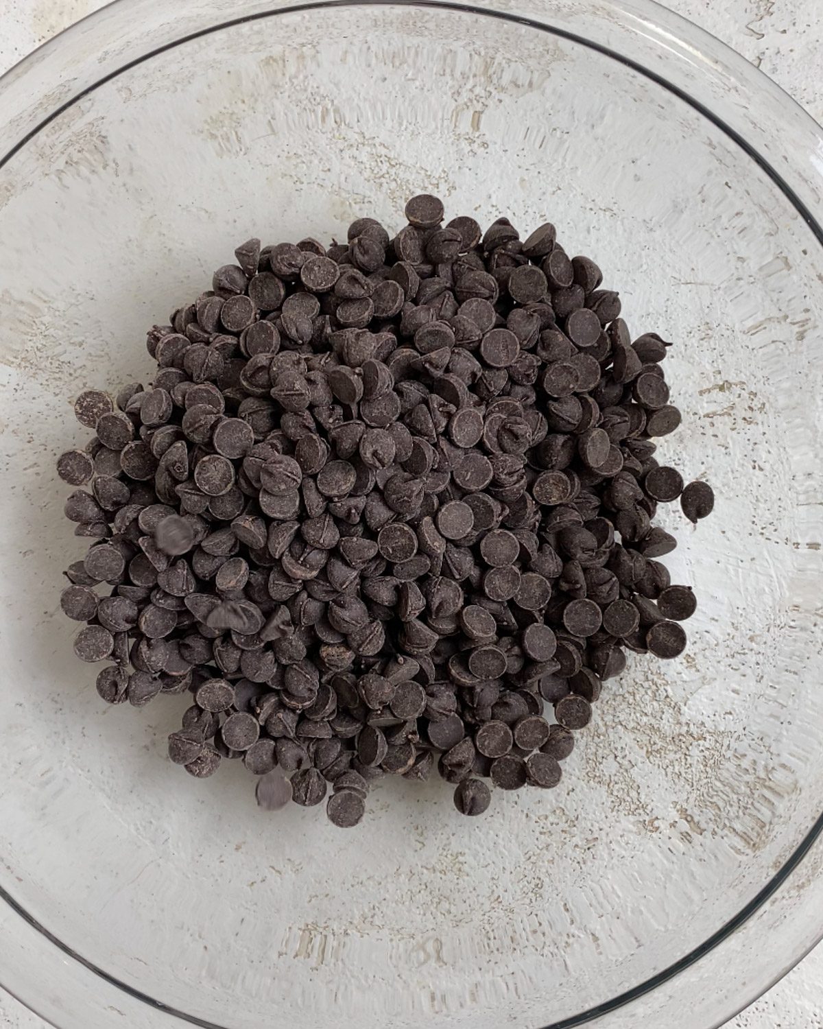 process shot of vegan chocolate chips added to glass bowl