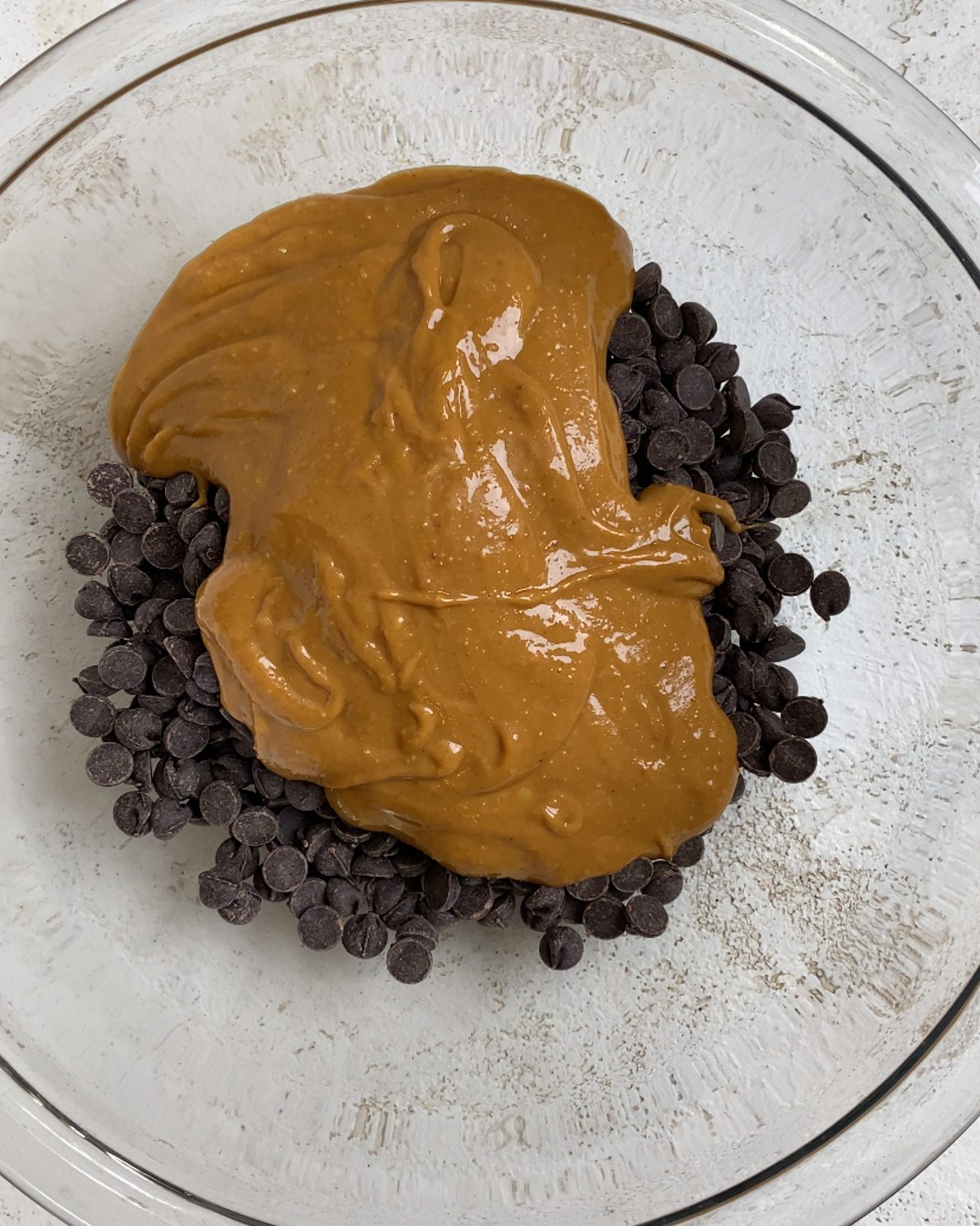 process shot of peanut butter added to glass bowl