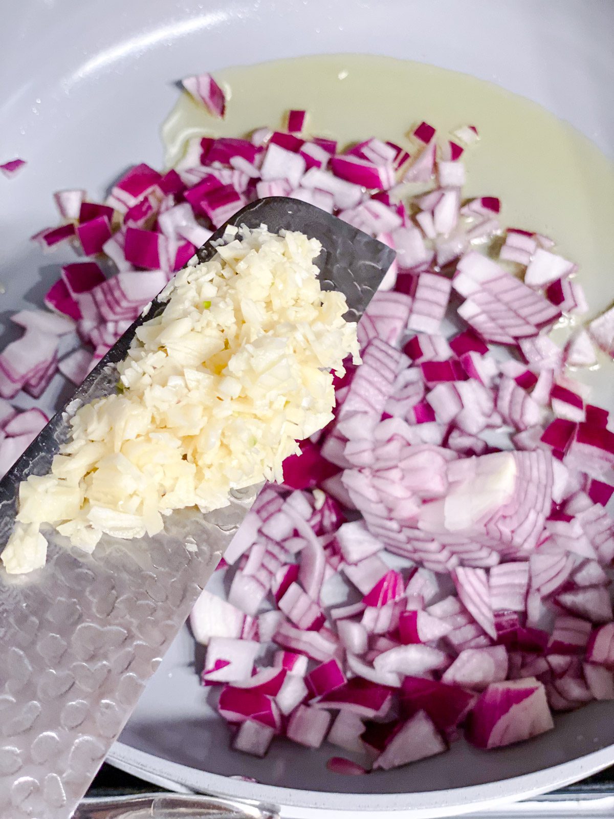 process of adding garlic to pan