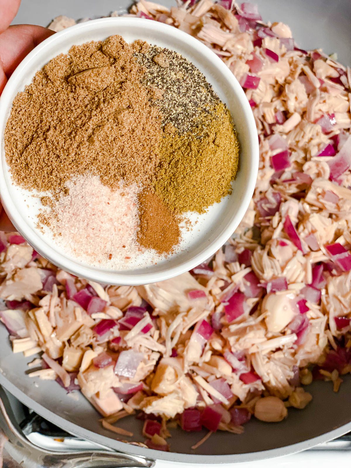 process of adding spices to a pan