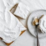 completed Fluffy Vegan Coconut Cake with a piece plated on a white plate