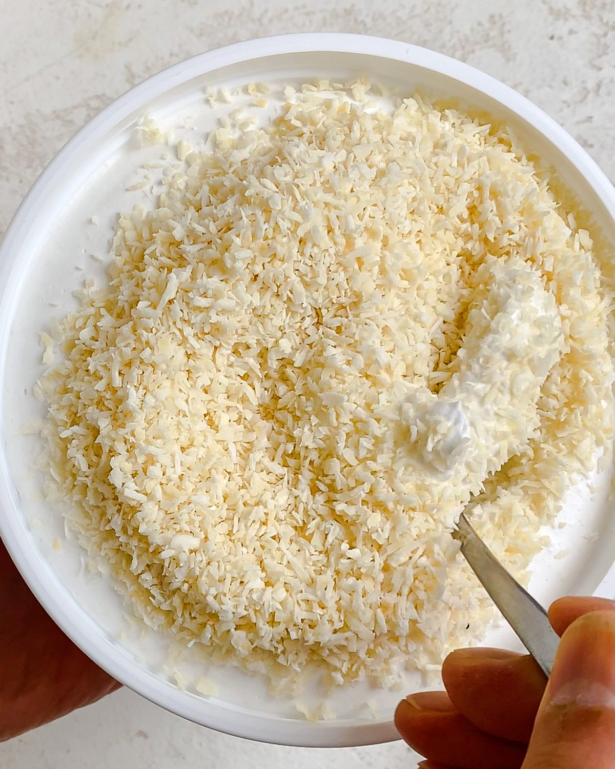 process shot of adding coconut shreds to bowl