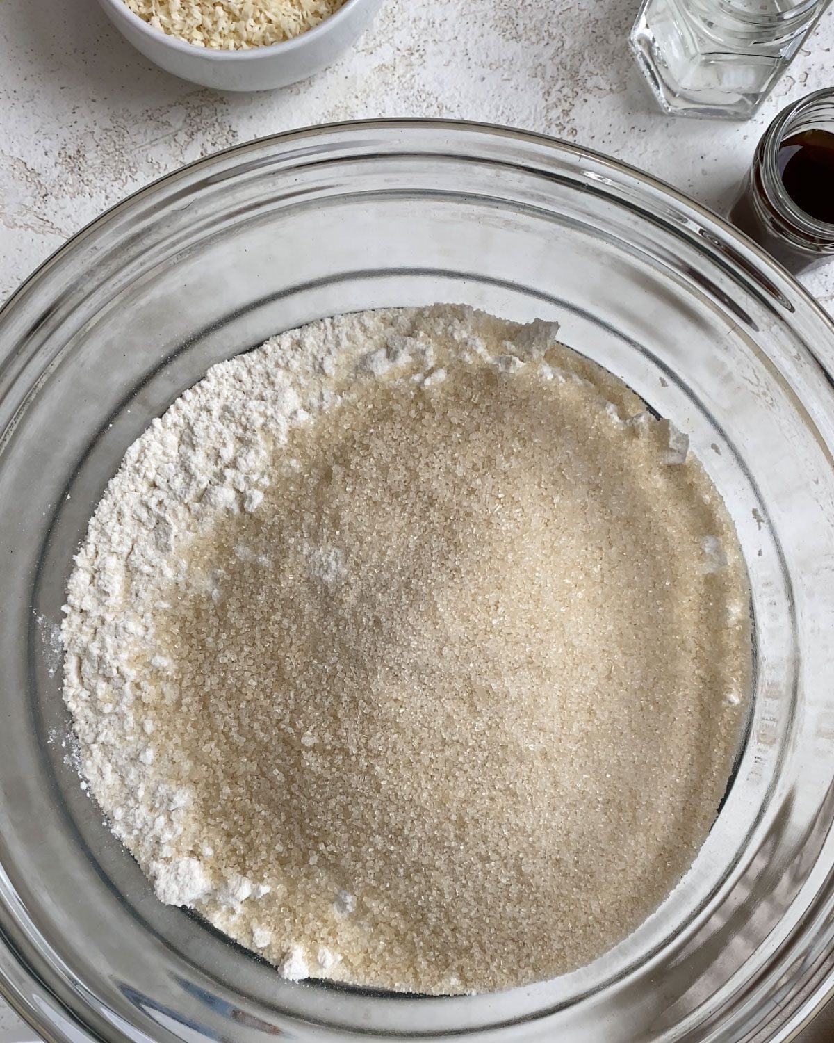 process shot of sugar added to glass bowl