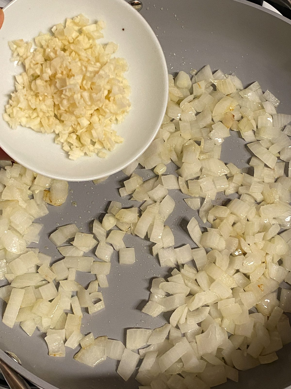 process shot of adding garlic to pan