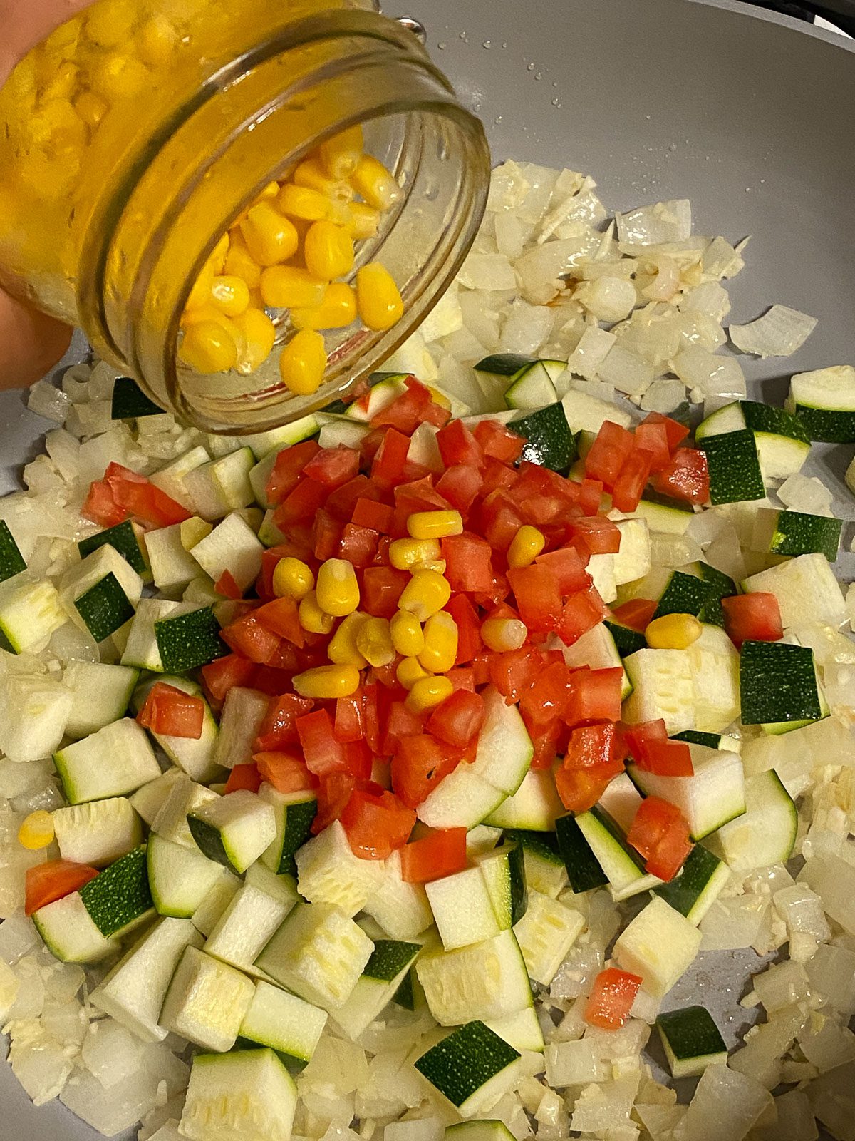 process shot of adding corn to pan