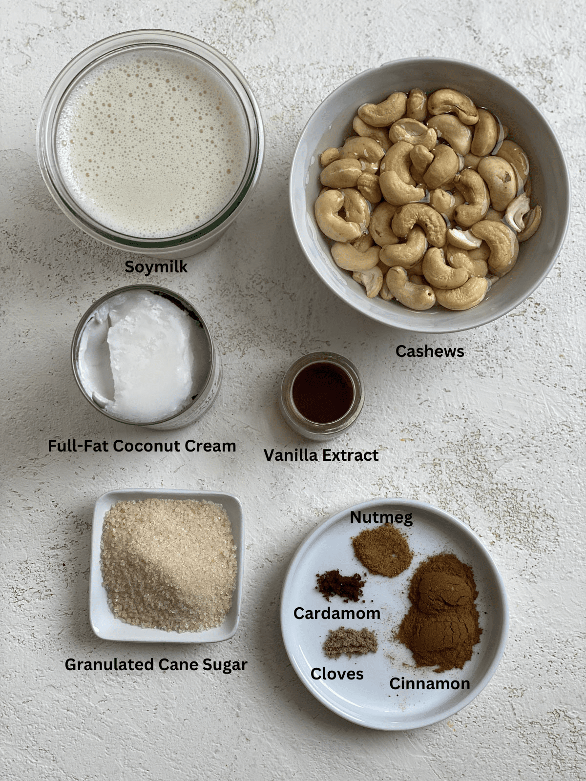 ingredients for Super Creamy Vegan Eggnog measured out against a white surface