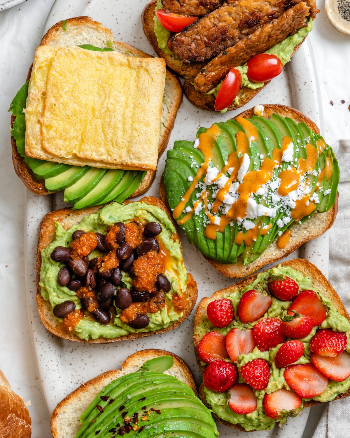 several completed pieces of avocado toast on a white surface