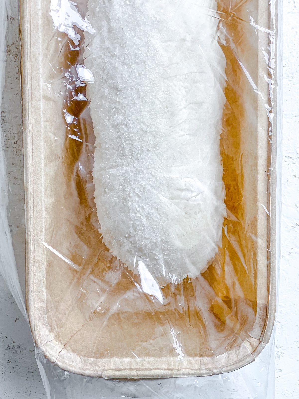 rhodes bread in bread loaf tin against a white surface