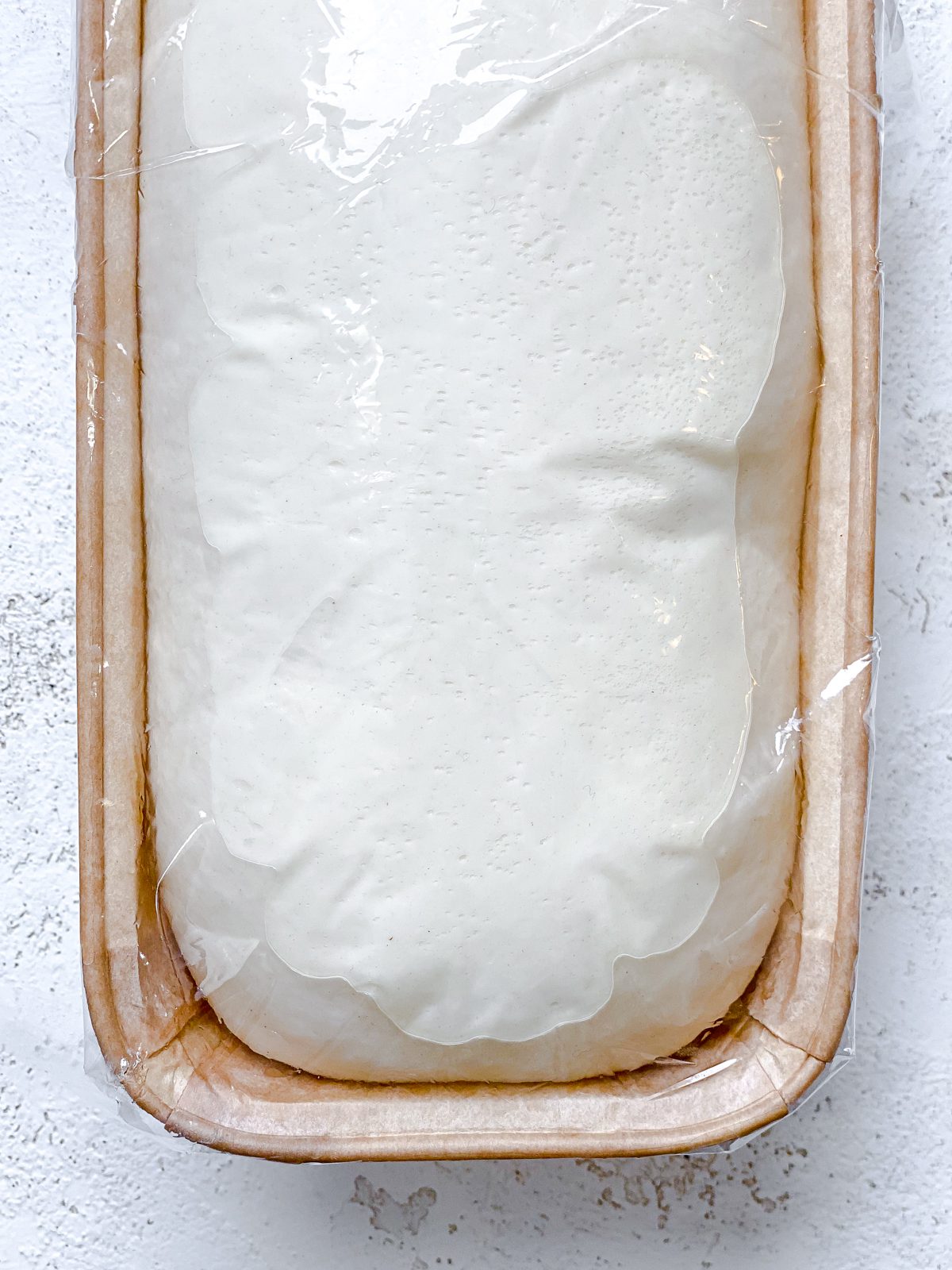 rhodes bread in bread loaf tin against a white surface