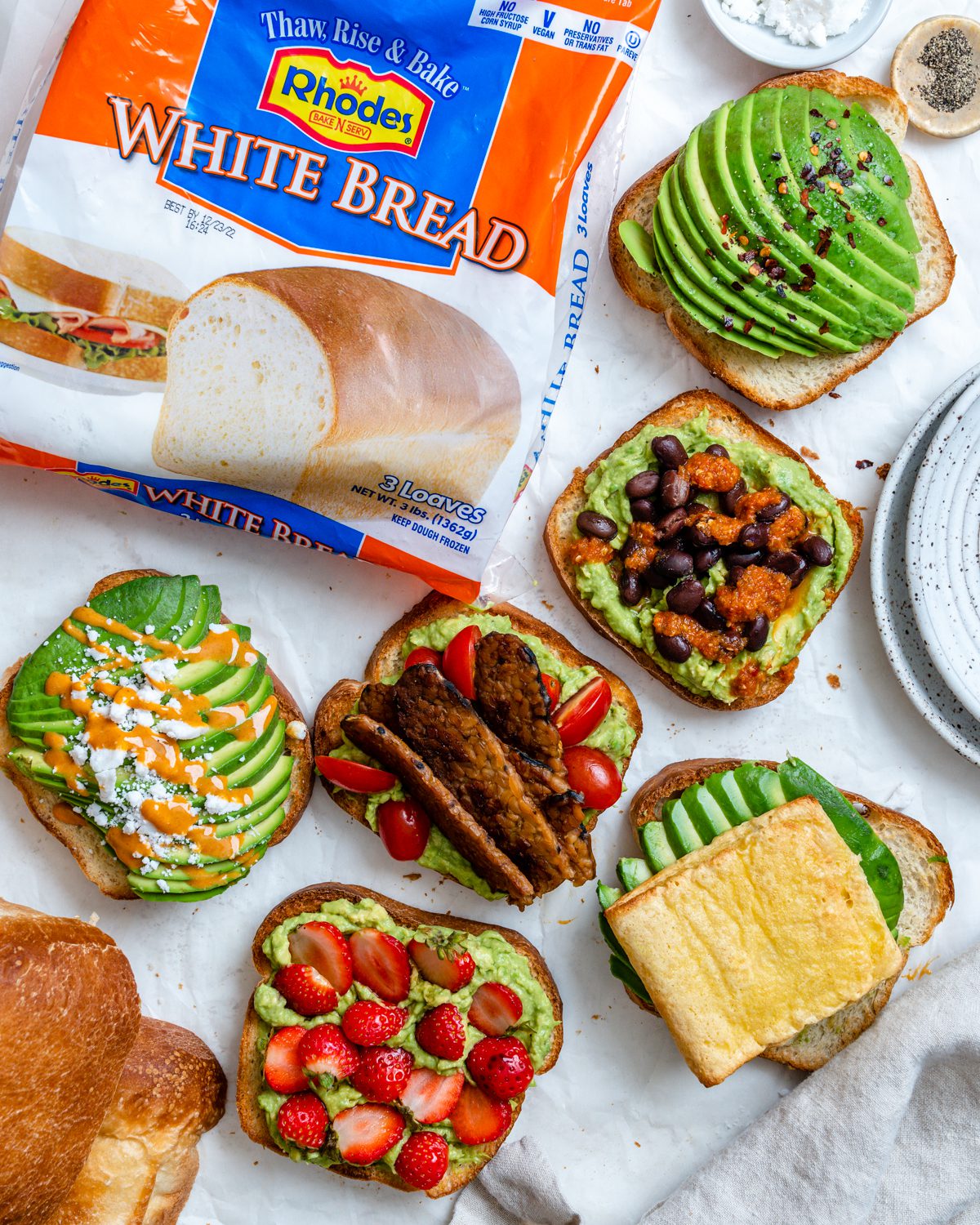 several completed pieces of avocado toast on a white surface