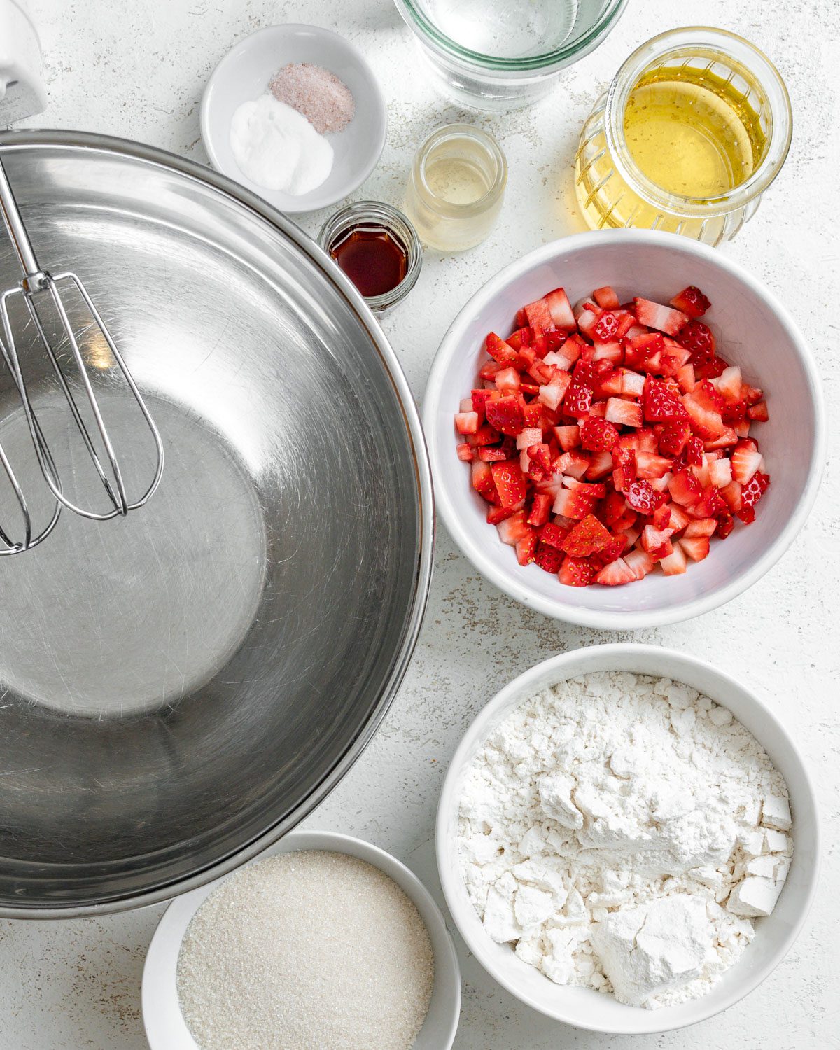 ingredients for Vegan Strawberry Cupcakes measured out against a white surface